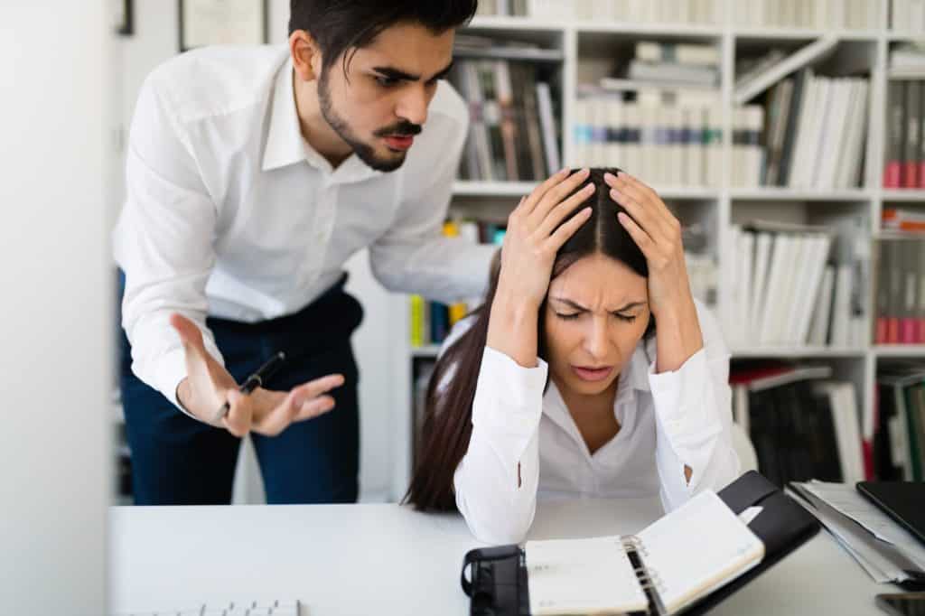 Angry boss yelling at his employee in office