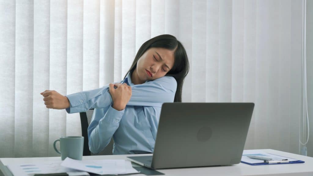Young asian women stretch their muscles while sitting at the office to relax from the stress.